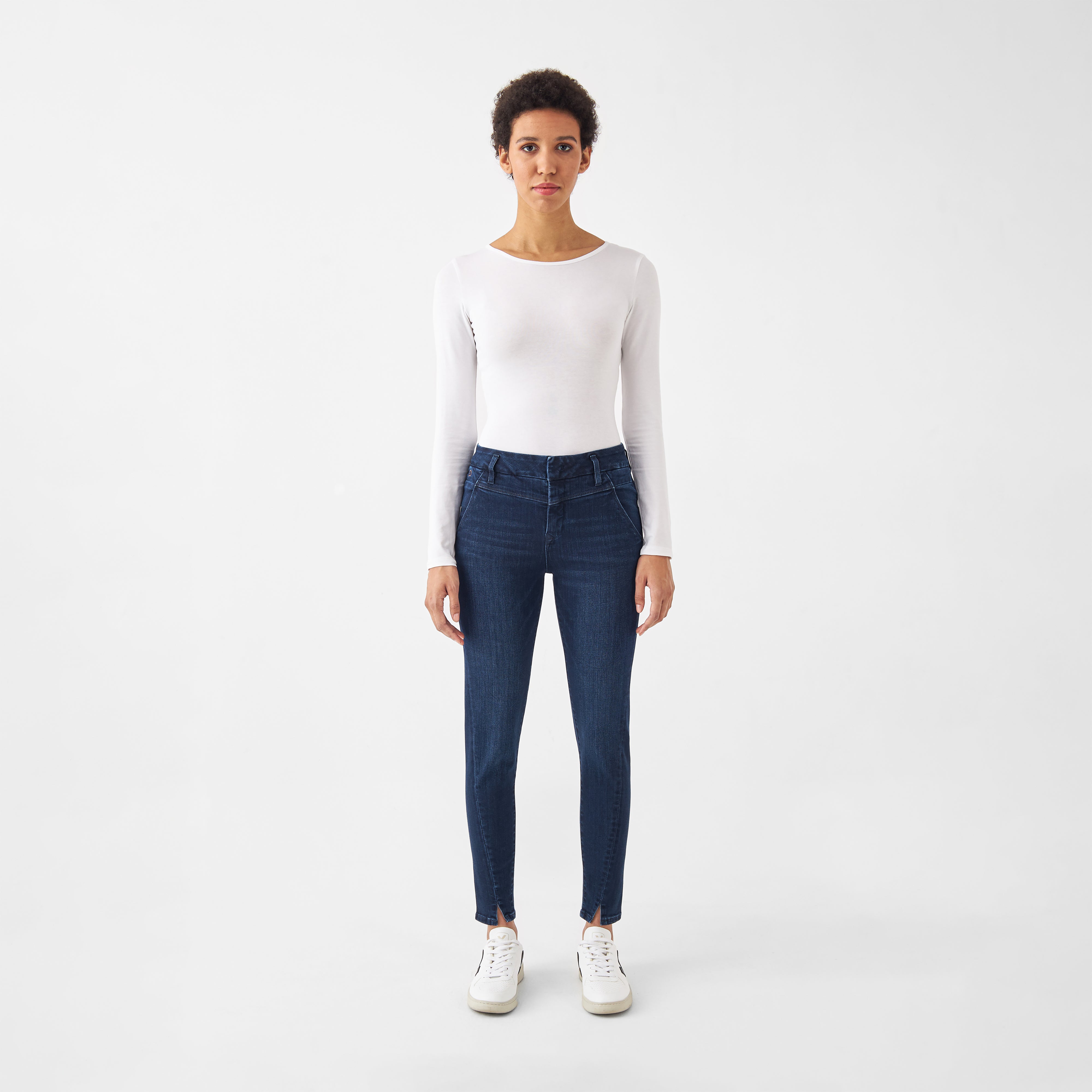 Dunkelblaue SUN UP Skinny Jeans mit Powerstretch, sitzt mittig auf Hüfte/Taille; schräge Außennaht und Saumschlitz, Model trägt weißes Langarmshirt.