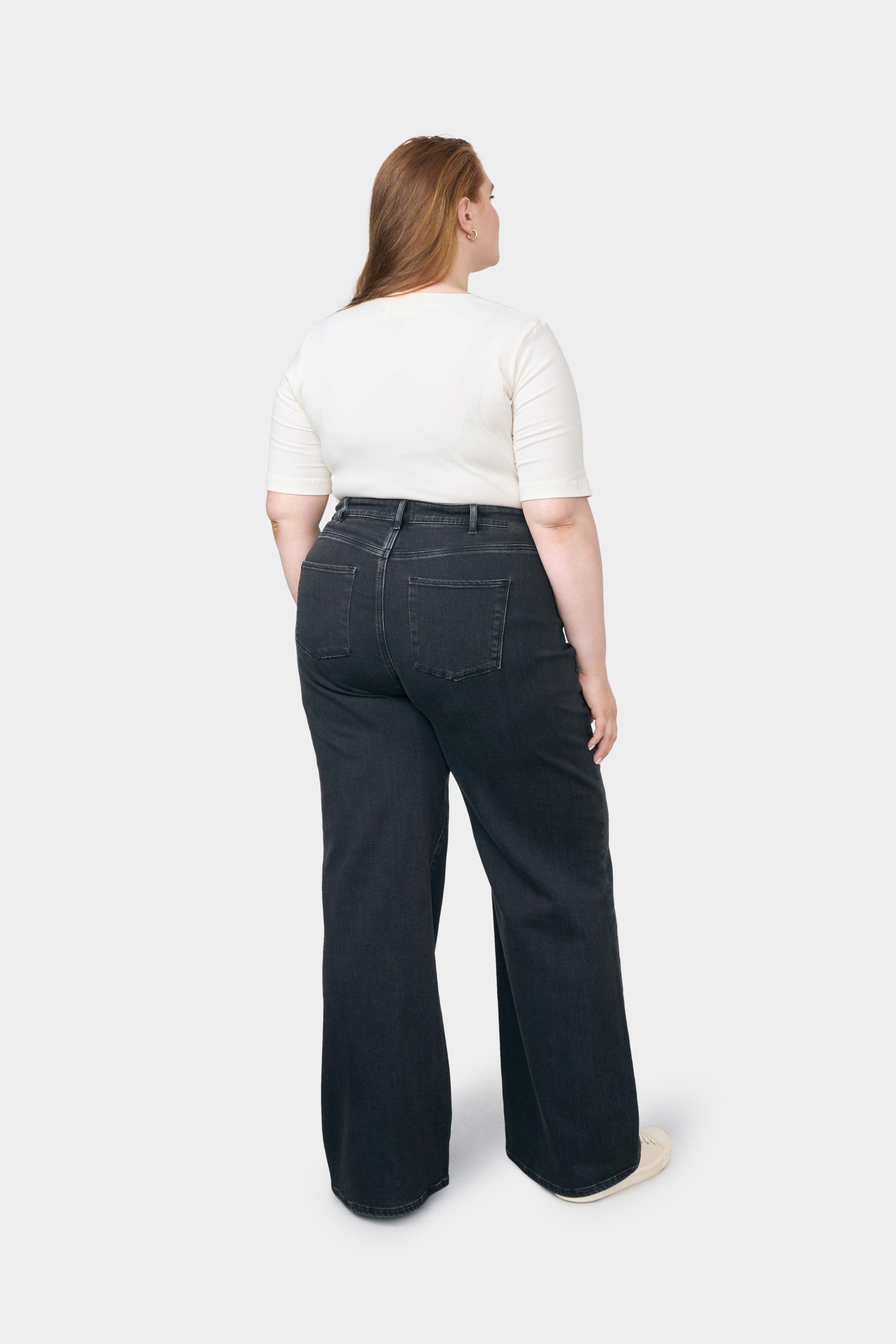 Rückenansicht einer curvy DEW Flared Soft Denim Jeans in Schwarz, hohe Taille, ausgestelltes Bein, Five-Pocket-Design.