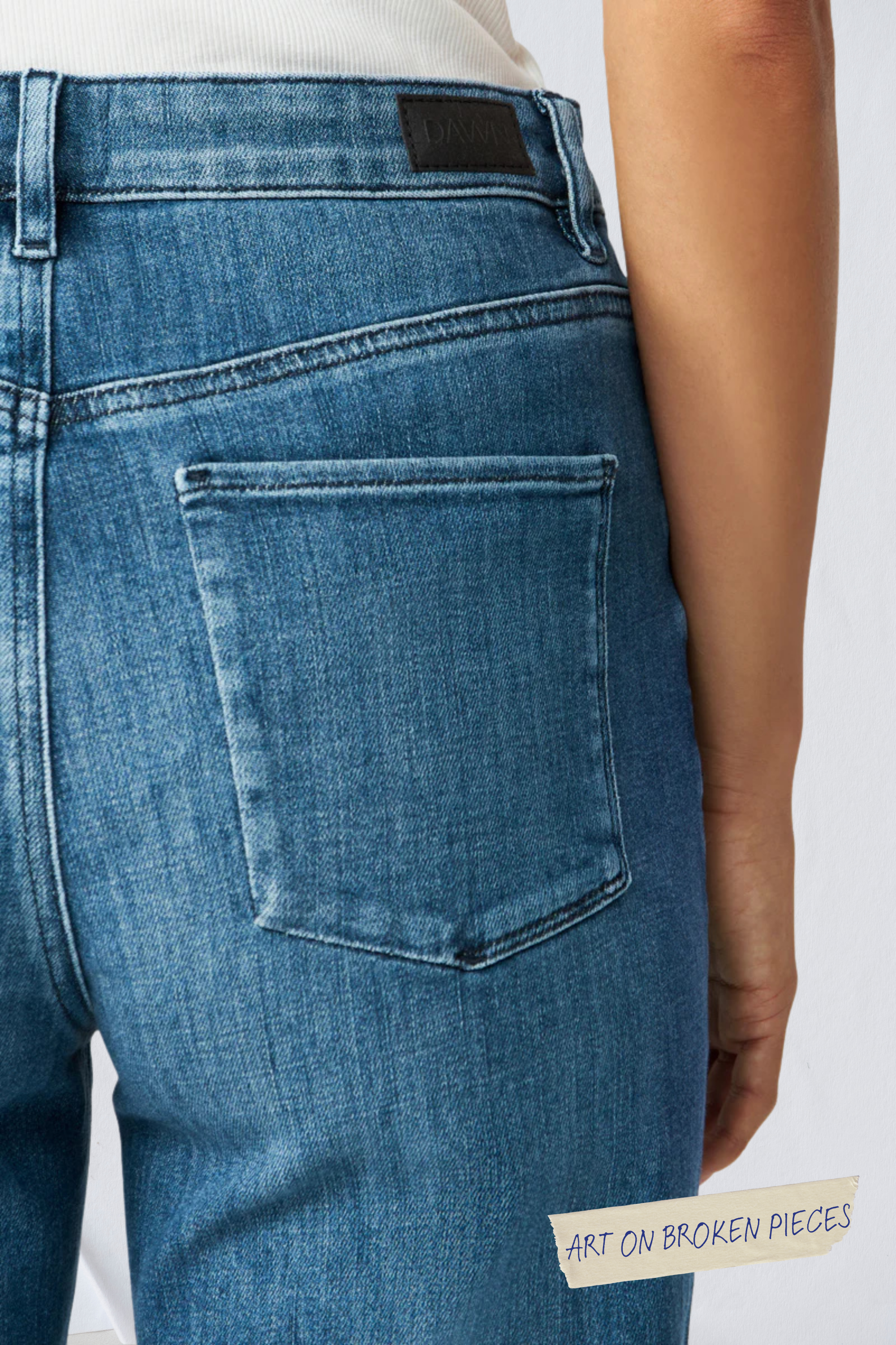 Rückansicht der DEW Classic Jeans in Medium Blue: hoher Bund, ausgestelltes Bein; DAWN-Label am Bund.