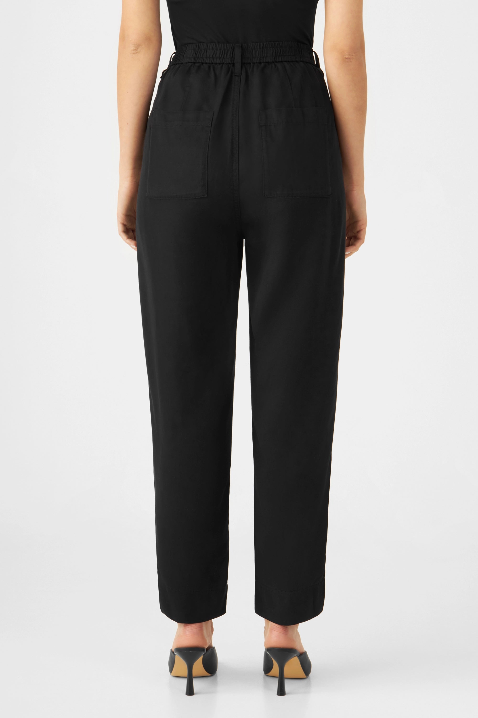Schwarze SUNSHINE Tapered Tencel Jogger in Midnight Black, Rückansicht: elastischer Rückenbund, zwei aufgesetzte Gesäßtaschen, lockere Passform, zum Saum hin schmal.