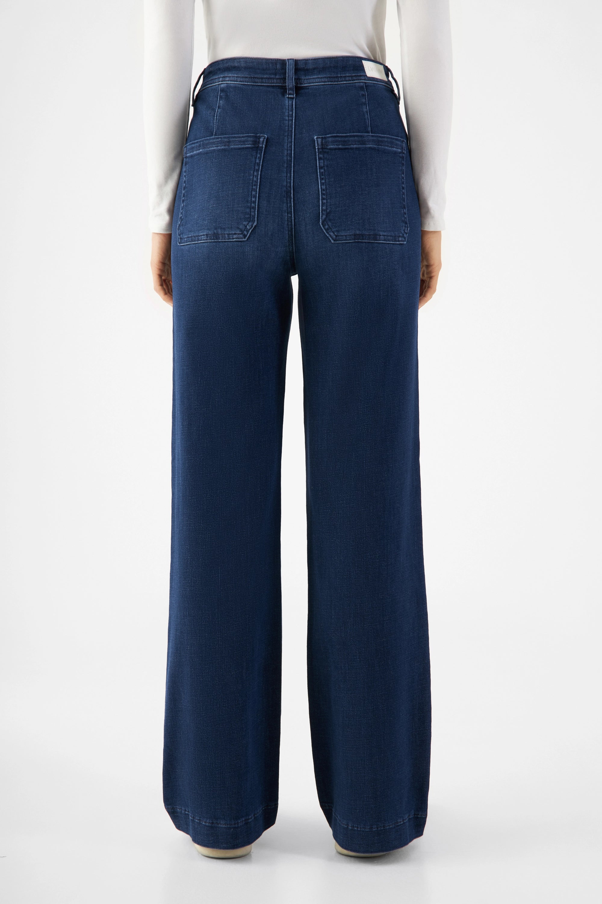 Rückansicht einer dunkelblauen DEW Sailor High-Waist-Jeans aus Organic Soft Denim mit zwei aufgesetzten Rückentaschen und weitem Bein.