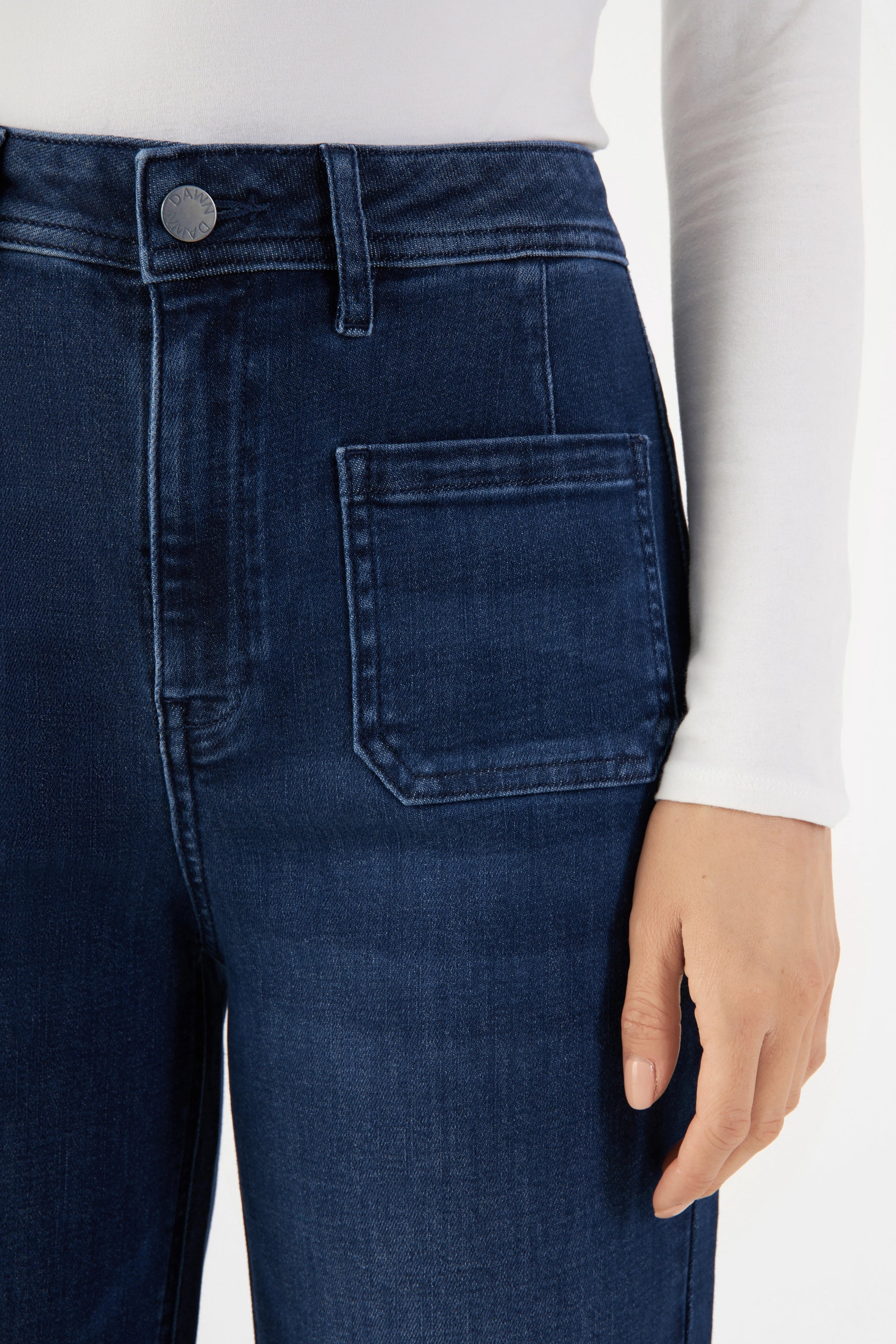Dunkelblaue High-Waist-Denimjeans im Sailor-Look mit aufgesetzten Taschen vorne; sichtbarer Bundknopf und Gürtelschlaufen.
