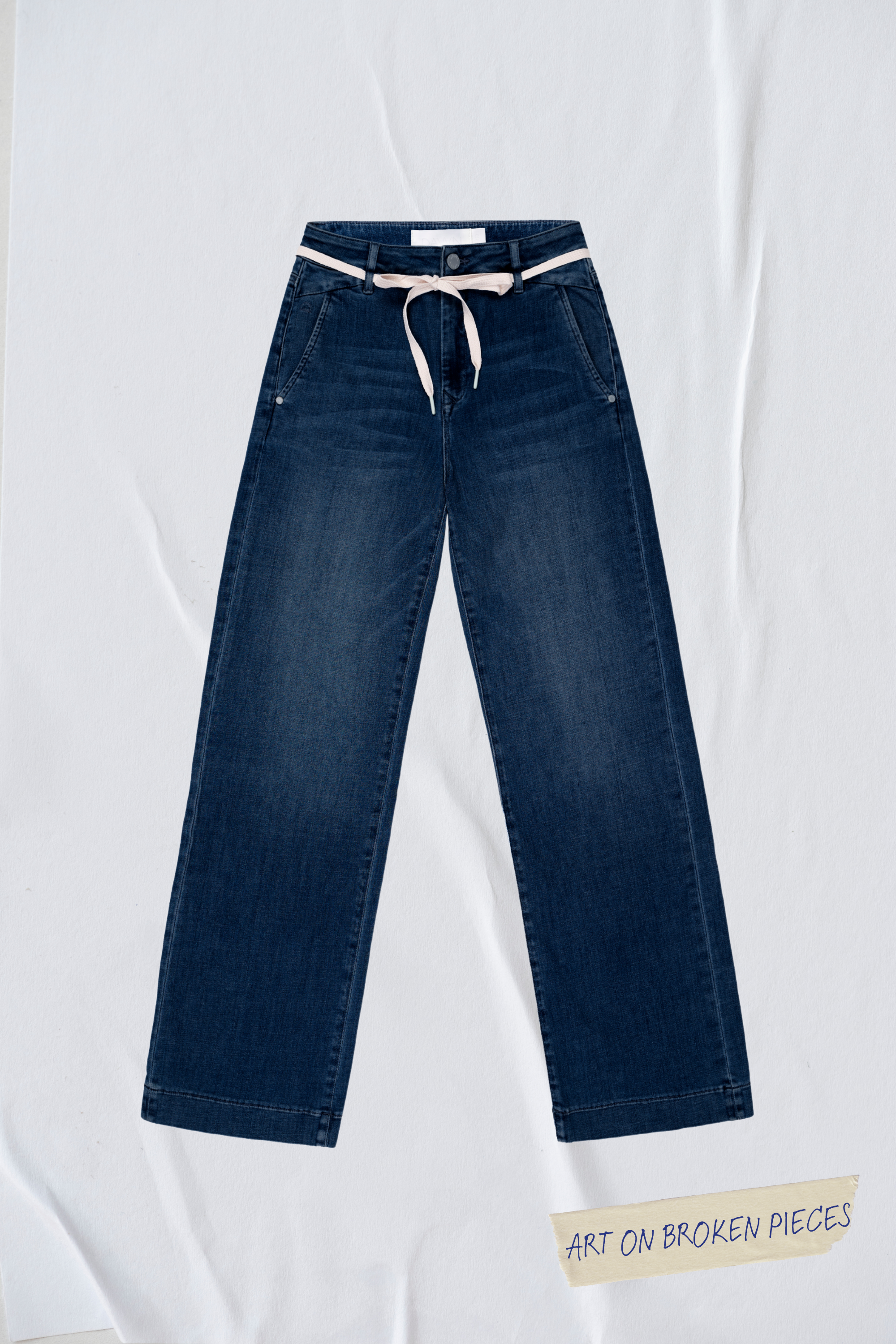 Dunkelblaue DEW Flared Jeans mit French Pocket, hoher Taille, ausgestelltem Bein; helles Gürtelband – Art on Broken Pieces.