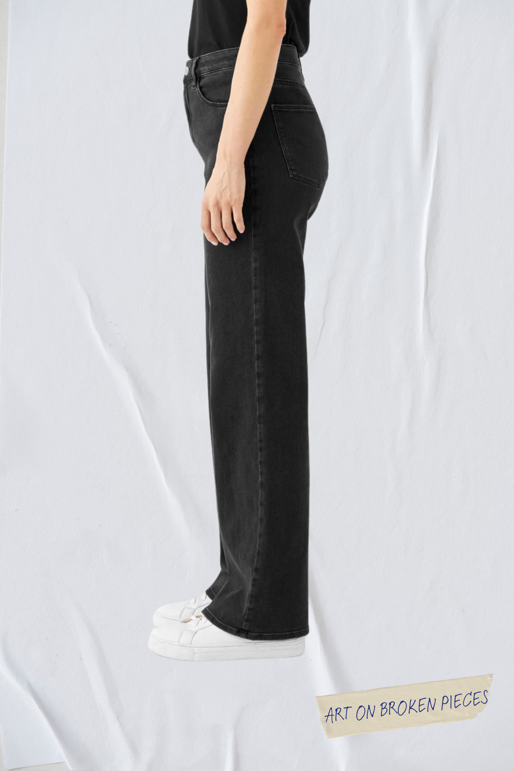 Seitliche Ansicht der schwarzen DEW Flared Jeans (Classic Black Denim) mit hohem Taillenbund, ausgestelltem Bein und Five-Pocket-Design.