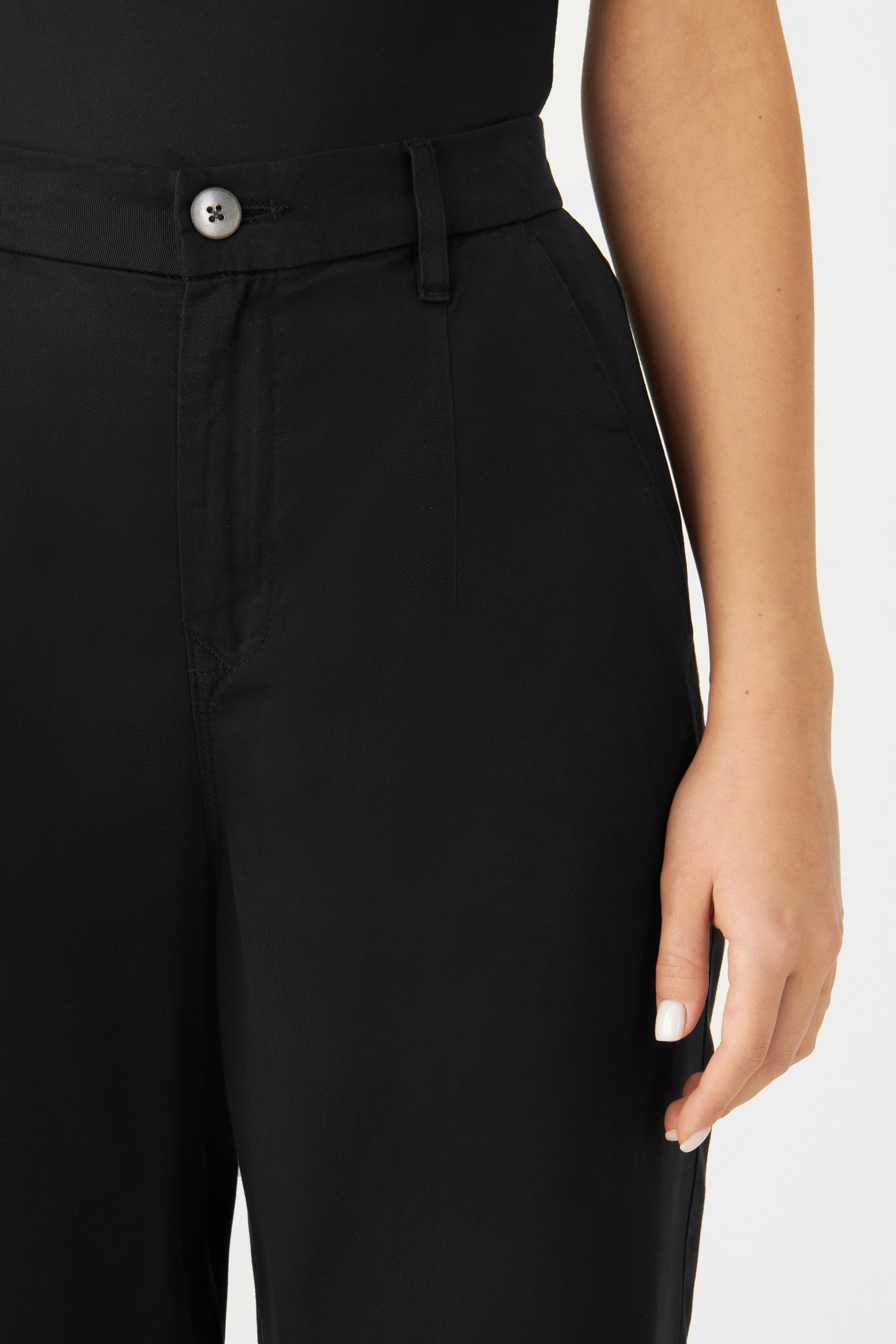 Schwarze SUNSHINE Tapered Tencel Jogger, Midnight Black; mittelhohe Taille, Knopfverschluss vorne und Gürtel-Schlaufen – Nahaufnahme des Taillenbereichs.